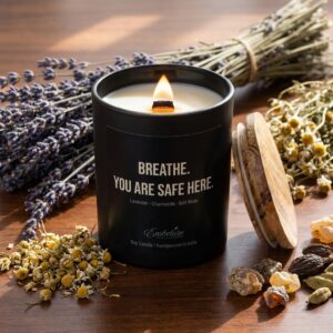 Premium raw ingredients including dried lavender buds and chamomile flowers spread around a black candle jar