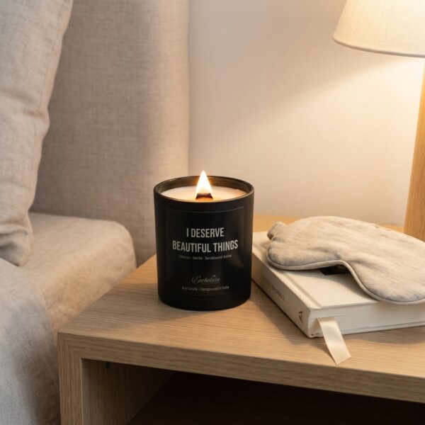 An upscale home office desk featuring a burning custom luxury candle next to a laptop and a cup of coffee.
